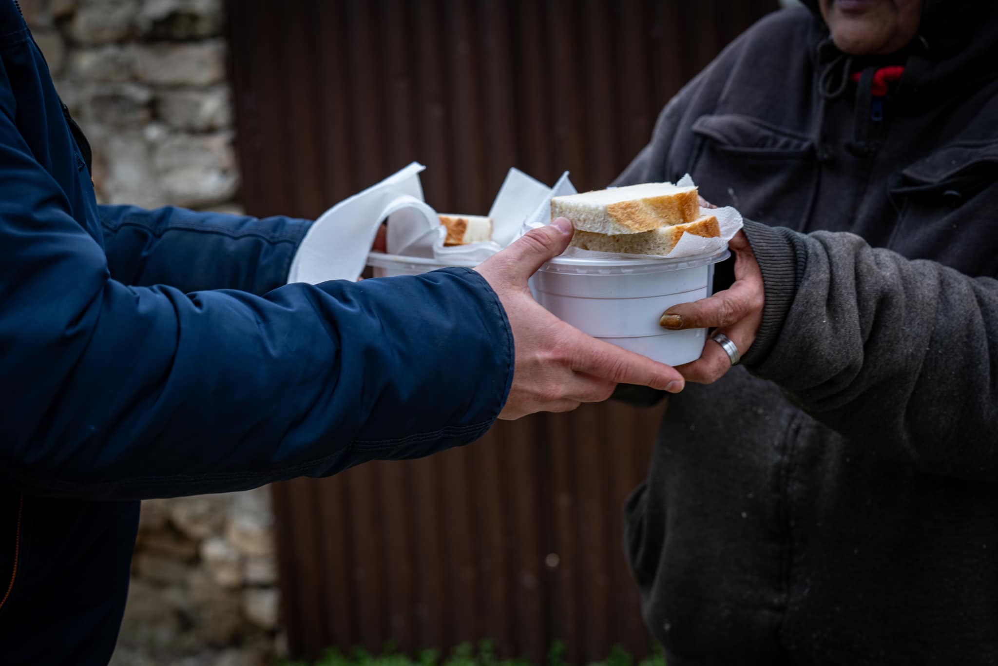 Handing over a meal and bread to someone in need