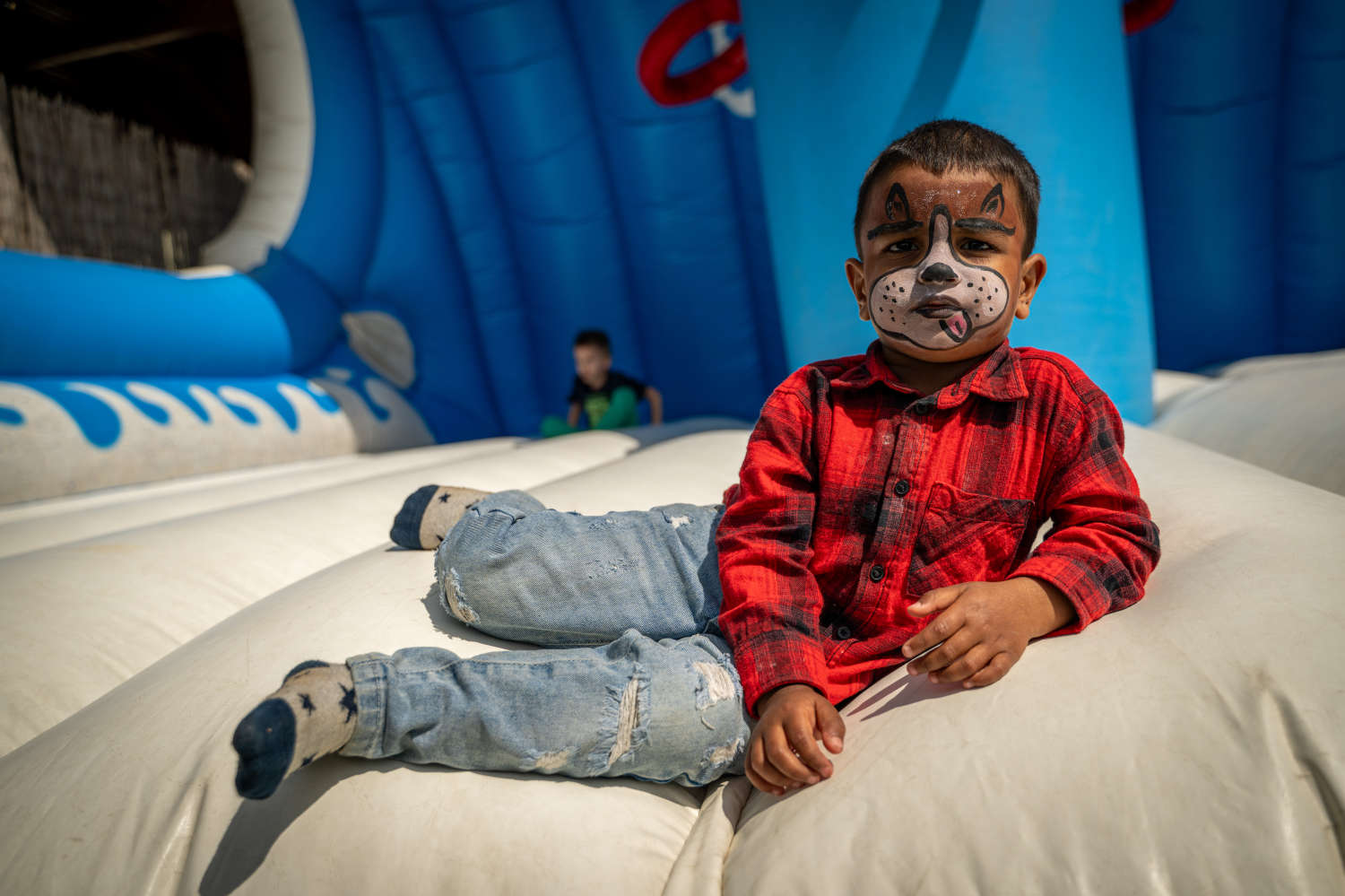 Face-painted boy in the bouncy castle
