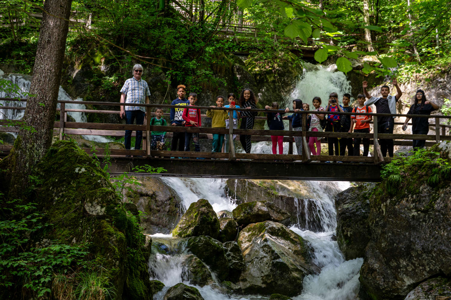 Group photo on a bridge over a waterfall